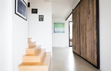 Image of staircase and custom barn door feature by Peninsula Homes